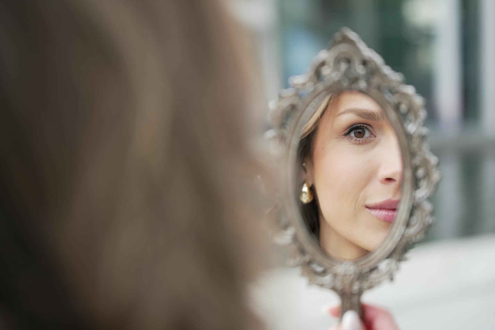 A woman looking in a mirror with her eyes